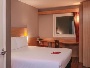 una camera d'albergo con un letto e una scrivania di ibis Lima Larco Miraflores a Lima Altre 111 foto