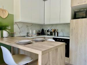 a kitchen with white cabinets and a wooden counter top at Verdant, Terrasse, proche mer in Trégastel