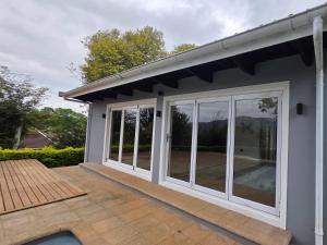 una casa con puertas correderas de cristal en un patio en Thornleigh Homestead, en Pietermaritzburg
