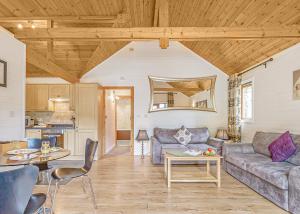 una sala de estar con un sofá y una mesa en Tilford Woods Lodge Retreat, en Farnham