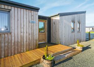 ein kleines Holzhaus mit einer Holzterrasse in der Unterkunft Castle Pren Lodges in Llanddewi Ystradenny + 8 Fotos
