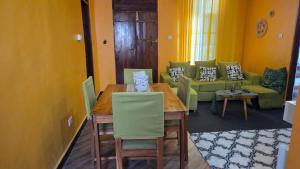 a dining room with a table and a couch at Sisters House in Pingwe