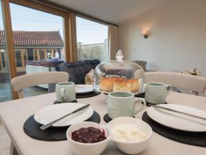 a table with a plate of food on it at Woodcrest Barn Cottage - Ukc1065 in Shelfanger