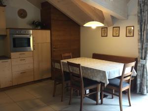 a kitchen with a table and chairs in a room at Appartamenti Clelia in Pellizzano