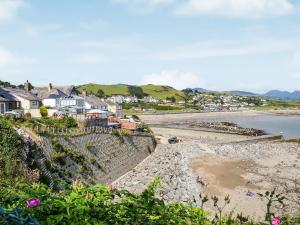 a view of a beach with houses and the ocean at Morlais in Criccieth