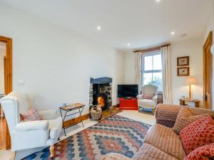 Una sala de estar con un sofá y una chimenea. en The Farmhouse - Uk48734, en Gaerwen