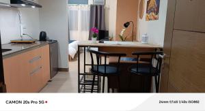 una cucina con 2 sgabelli da bar e bancone di Makati San Antonio Residence Staycation a Sampong