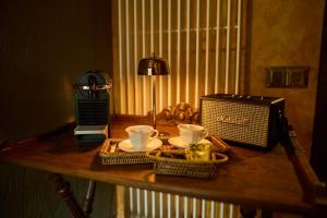 a table with two coffee cups and a radio at Hotel Valle de Pineta - Las Suites in Bielsa