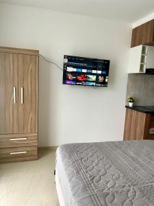 a bedroom with a bed and a flat screen tv on the wall at Tu Oasis en el Centro in Santa Cruz de la Sierra +12 photos