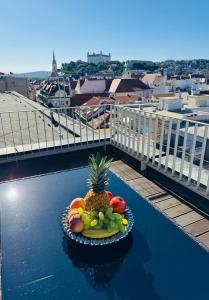 a plate of fruit on a table on a balcony at Luxury PENTHOUSE at the Historical Centre Parking in Bratislava