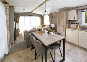 a kitchen and living room with a table and chairs at Burtree Lakes Holiday Park in Bedale +1 photo