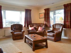 a living room with leather chairs and a coffee table at Crossfeld in Keswick