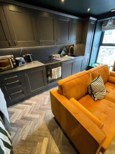 a living room with an orange couch in a kitchen at The Hideaway Bureau - Islay in Wooler