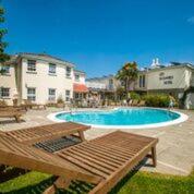 uma piscina com uma mesa de piquenique e um banco em Les Douvres Hotel em St Martin Guernsey