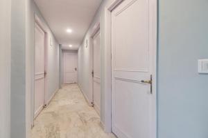 a hallway with white walls and a white door at Hotel O Blue moon in New Delhi