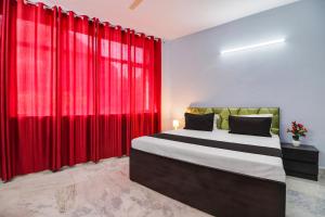 a bedroom with a large bed with red curtains at Hotel O Blue moon in New Delhi