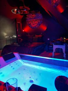 a hot tub in a room with red lights at La Sainteny Touch in Sainteny