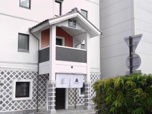 a white building with a black and white facade at MATSUMOTO CASTLE hostel in Matsumoto