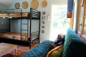 a living room with bunk beds and a couch at Domek Wróżki - Sanktuarium Laparica w Puszczy Białej 