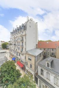 une vue aérienne d'un bâtiment blanc dans une rue de la ville dans l'établissement Le Sainte Barbe - Hyper Centre - Parc des sources, à Vichy