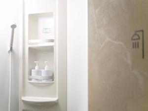 a bathroom with a white toilet in a room at MATSUMOTO CASTLE hostel in Matsumoto