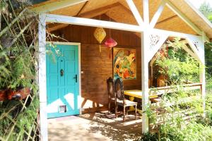 a house with a blue door and a table and chairs at Domek Wróżki - Sanktuarium Laparica w Puszczy Białej 