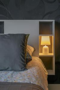 a bedroom with a bed with a lamp on it at Le Sainte Barbe - Hyper Centre - Parc des sources in Vichy