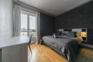 a bedroom with a bed and a window and a desk at Le Sainte Barbe - Hyper Centre - Parc des sources in Vichy