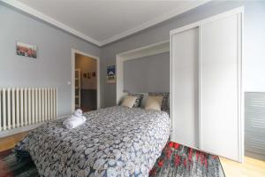 a bedroom with a bed with a teddy bear on it at Le Sainte Barbe - Hyper Centre - Parc des sources in Vichy +36 photos