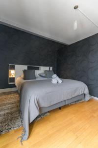 a bedroom with a bed with a black wall at Le Sainte Barbe - Hyper Centre - Parc des sources in Vichy