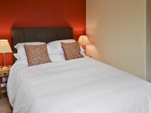 En eller flere senge i et værelse på Rosehip Cottage