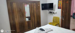 a bedroom with a bed and a cabinet and a television at VR Jardin Resort in Pondicherry