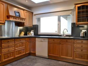 a kitchen with wooden cabinets and a window at Crossfeld in Keswick