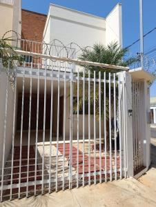 a white fence in front of a house at Apartmento duplex in Araxá
