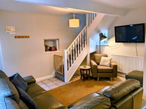 a living room with a couch and a tv at Little John Hotel in Hathersage