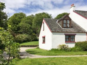 a white house with red windows and a driveway at Innish Beag - Uk38782 in Clachan