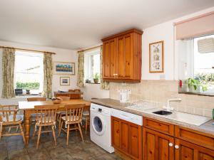 una cucina con tavolo e lavatrice di Ivy Cottage a Settle