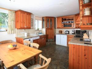 una cucina con mobili in legno e un tavolo in legno di Ivy Cottage a Settle