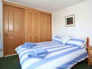 una camera da letto con un letto con asciugamani blu sopra di Ivy Cottage a Settle