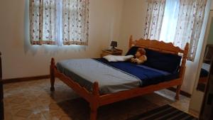 金斯敦Sea View Guest Apt的一只泰迪熊坐在卧室的床上