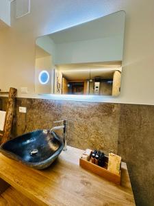 bagno con lavandino nero e specchio di Mulini 22 - Chalet & spa apartments a Temù Altre 52 foto
