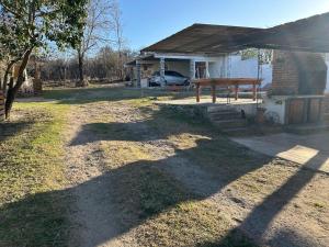 une maison avec une table de pique-nique dans la cour dans l'établissement Lo De ADRI, à Villa Carlos Paz