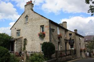 an old stone building with flowers on it at Ramblers Rest in Castleton