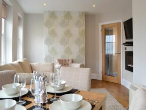 a living room with a table with wine glasses at Cliff Railway Apartment in Aberystwyth