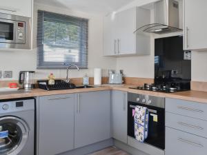 a kitchen with white cabinets and a dishwasher at Lodge 10 Bridlington Holiday Park - Uk48212 in Carnaby