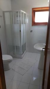 a bathroom with a shower and a toilet and a sink at Case Verdemare Stintino in Stintino +18 photos