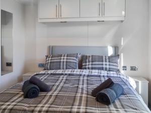 a bed with two pillows and towels on it at Lodge 10 Bridlington Holiday Park - Uk48212 in Carnaby +7 photos