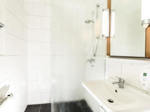 a white bathroom with a sink and a mirror at ibis Hotel Eisenach in Eisenach