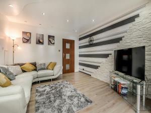 a living room with a white couch and a tv at Cherrytrees in Scarborough
