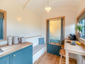 a kitchen with blue cabinets and a bed in a room at Shepherd's Retreat in Ongar